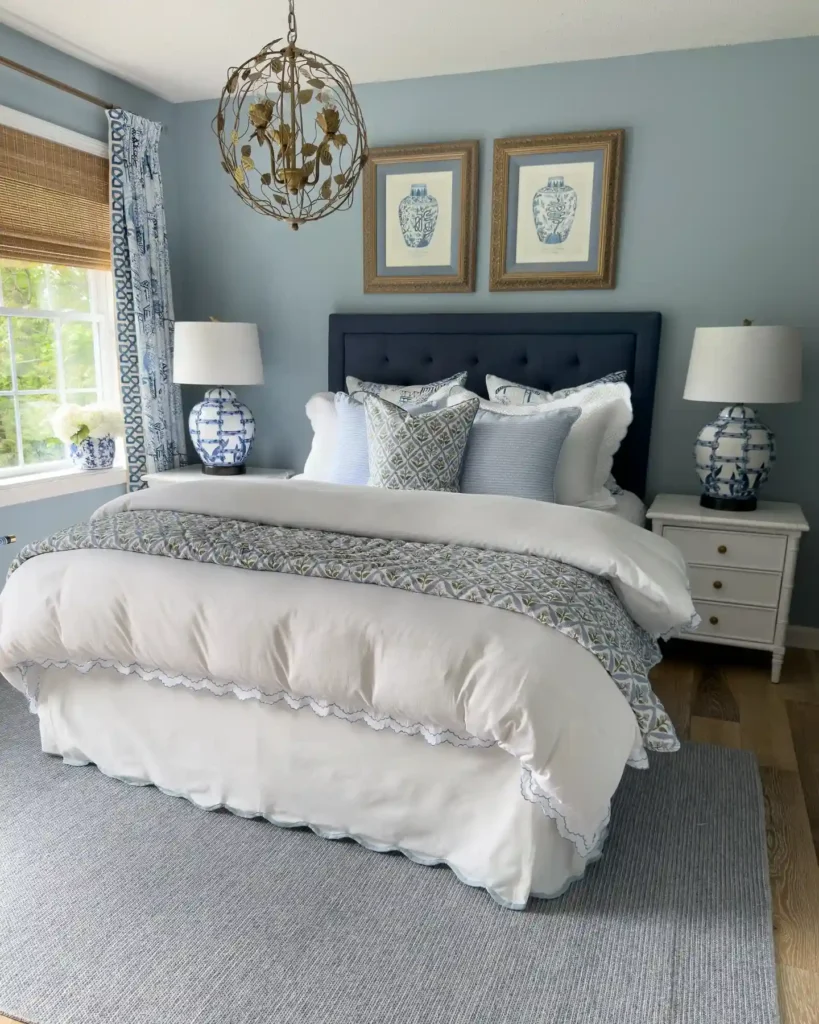 Elegant guest bedroom bedding in blue and white with patterned pillows and tufted headboard.