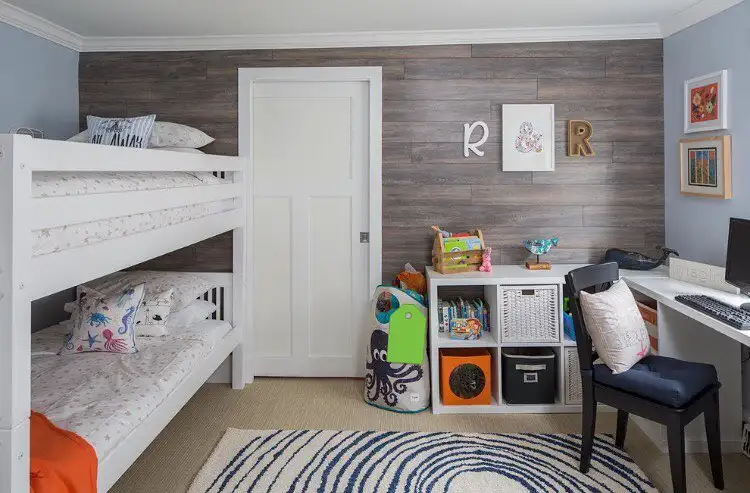 Boy and girl shared bedroom with bunk beds, wooden accent wall, and functional storage.