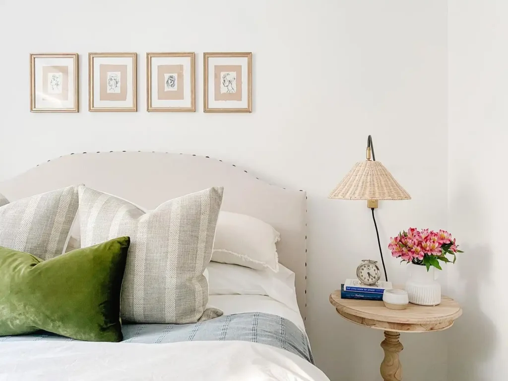 Guest bedroom idea in a budget with light bedding, green accent pillow, and wooden nightstand.