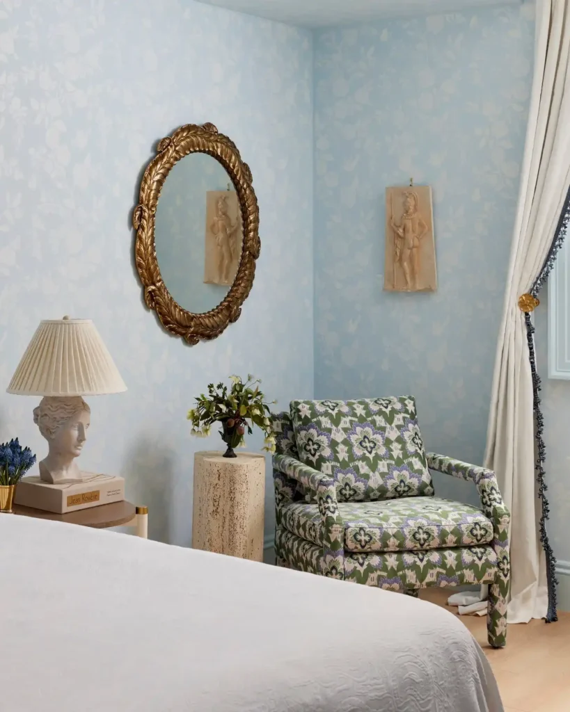Basement guest bedroom with black accent wall, patterned throw pillows, and modern lamps.