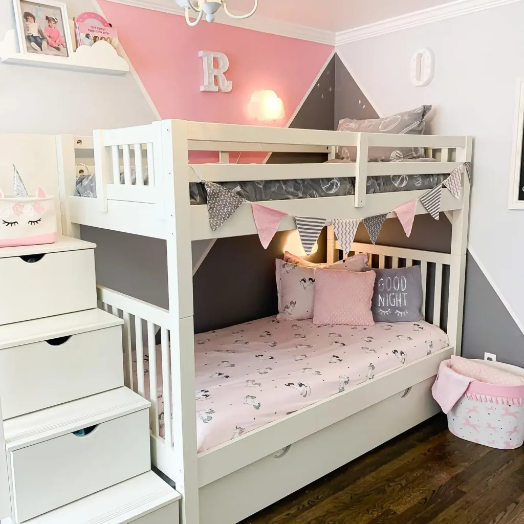 Stylish boy and girl shared bedroom with bunk beds, pink and gray theme, and playful décor.