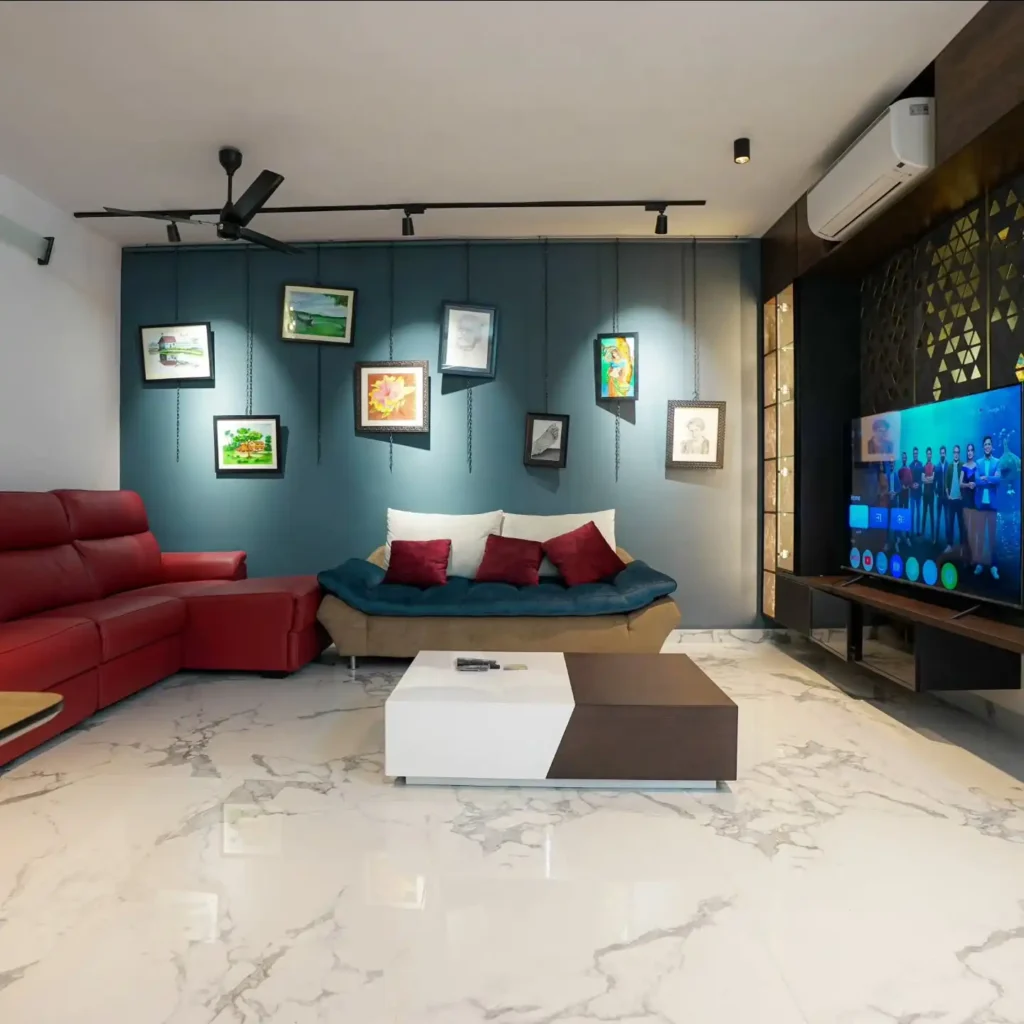 Bold living room with hanging framed artwork, red sectional sofa, and modern blue accent wall showcasing unique wall decor ideas above couch.
