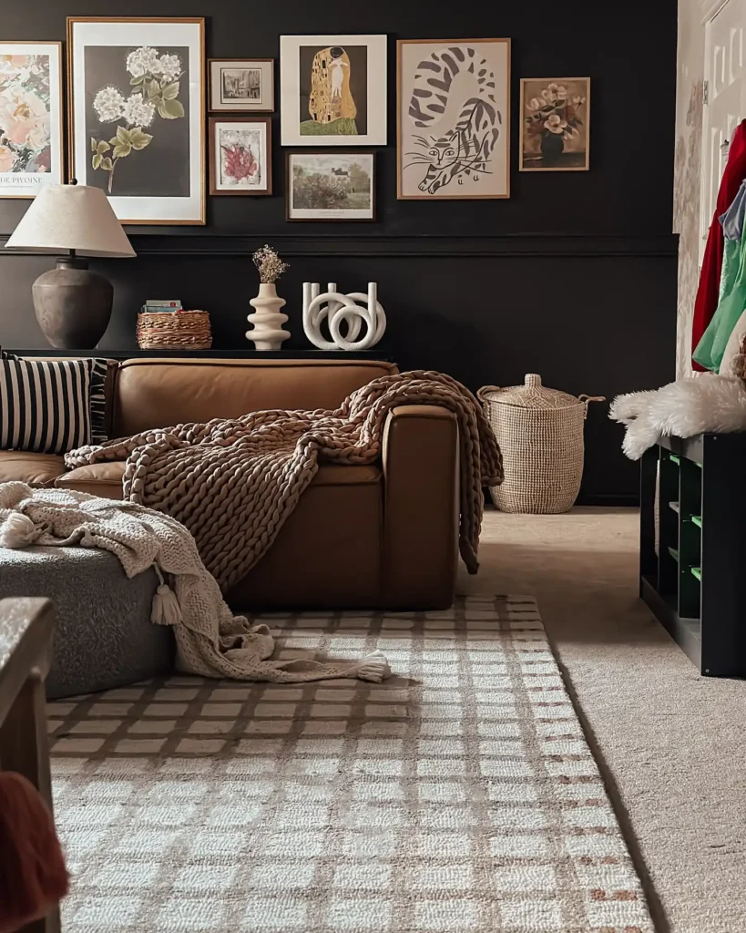 Dark wall living room with brown leather sofa, layered gallery wall, and cozy throws for stylish wall decor ideas above couch.