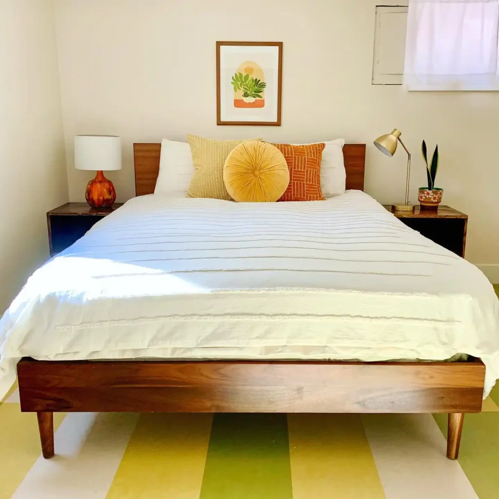 bedroom geometric wallpaper, single bed, and red lamp.