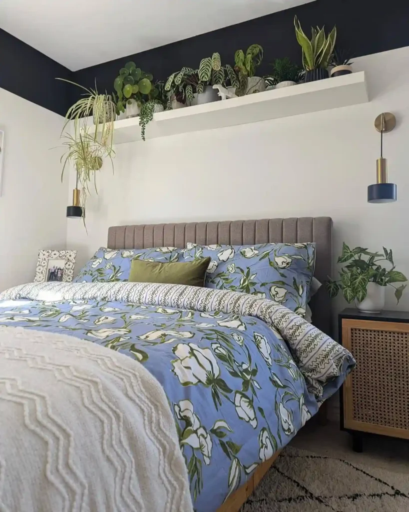 bold blue floral duvet, green pillows, and lush indoor plants.