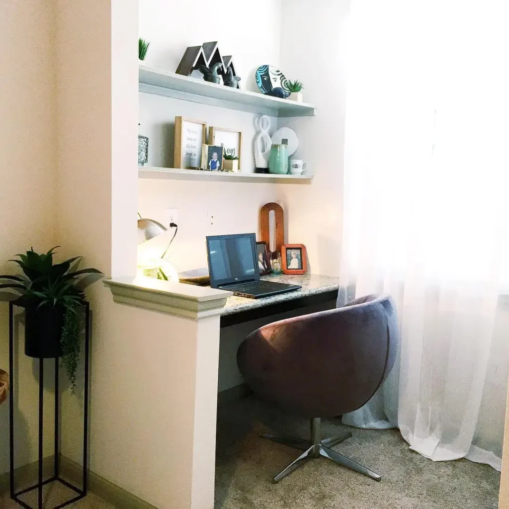 bedroom office with built-in desk, shelves, and soft chair