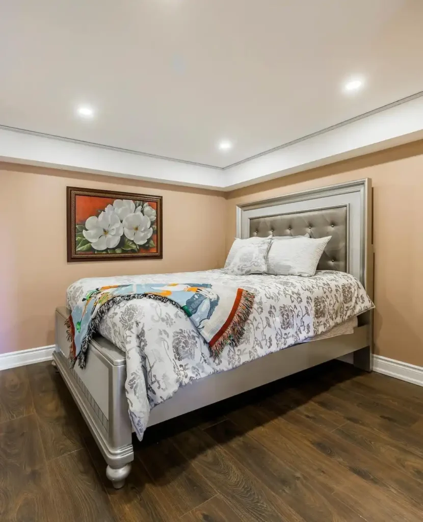 Guest bedroom with white bedding, black headboard, and pampas grass décor.
