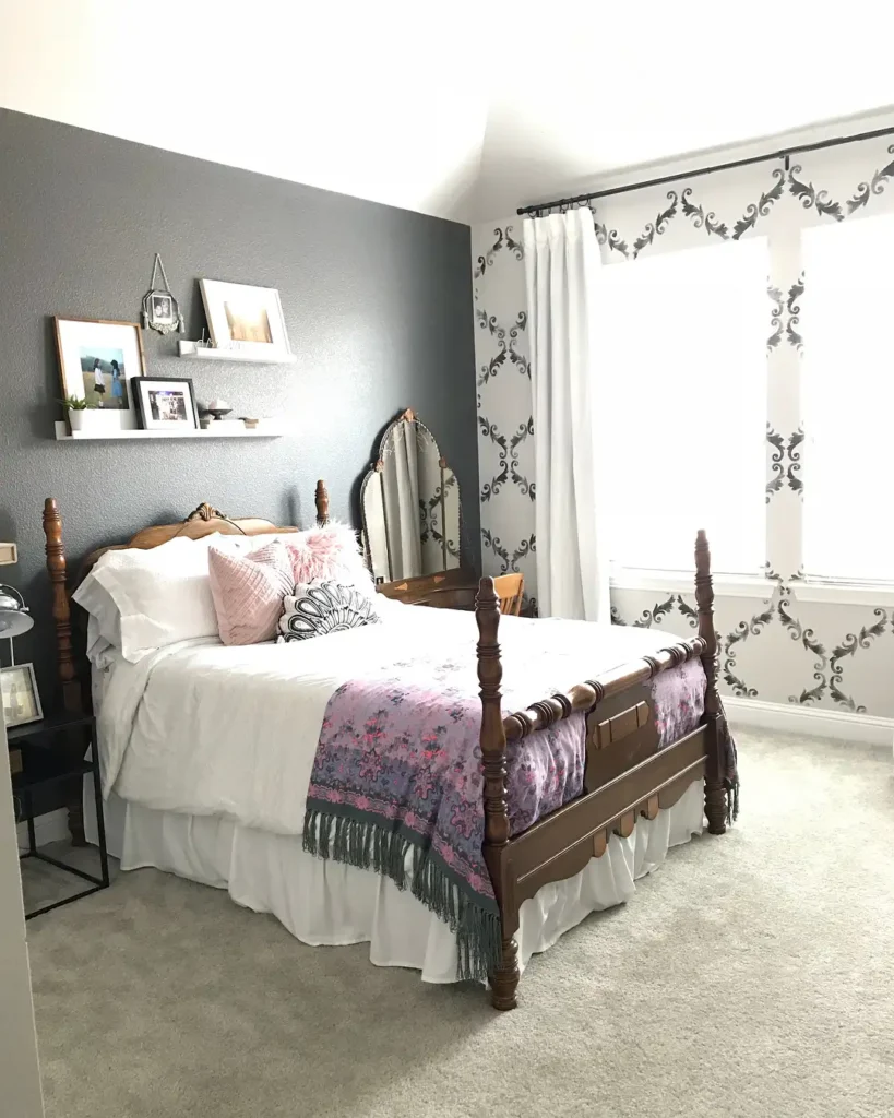 Preteen girls bedroom featuring wooden bed frame, classic mirror, white bedding, and accent pillows with pink and black.
