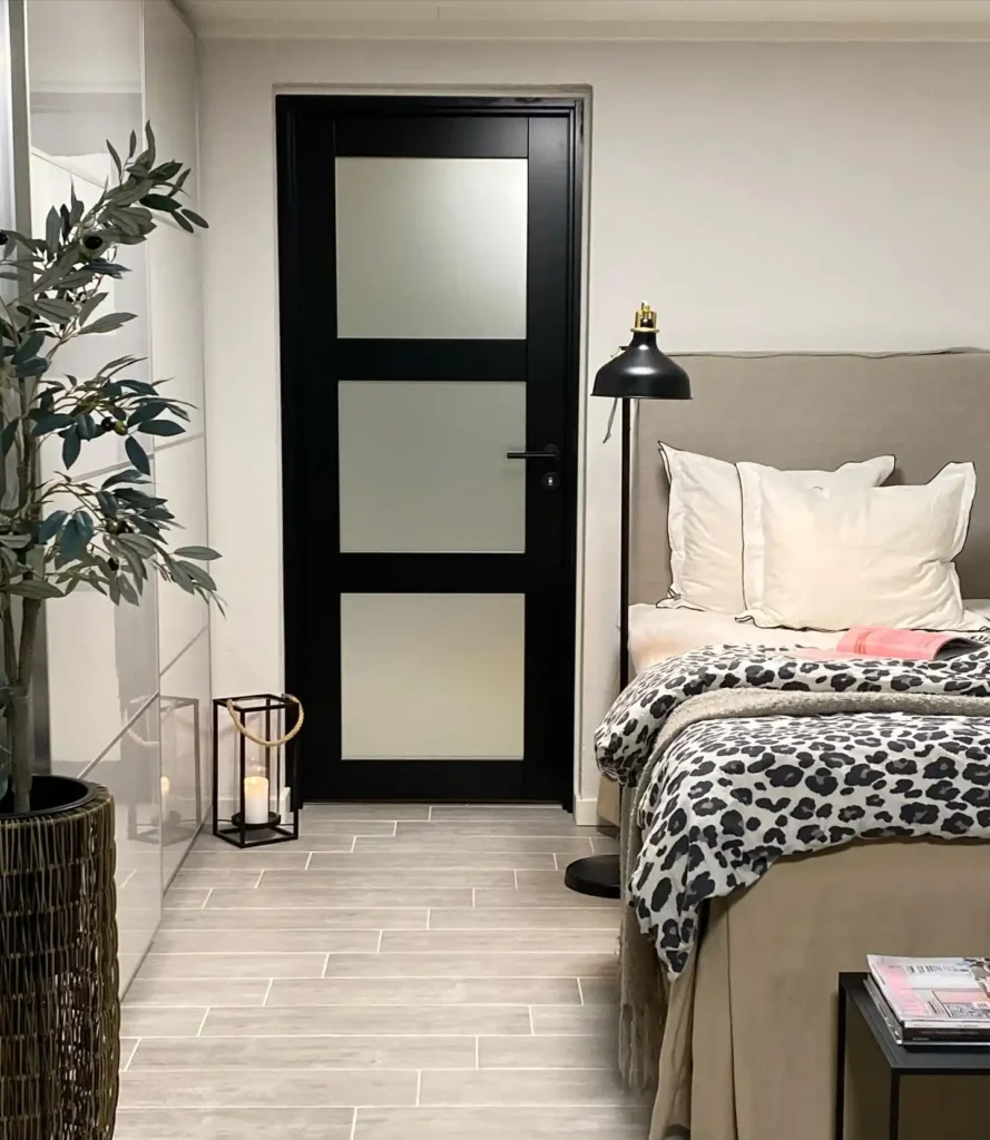 Guest bedroom with gray bedding, striped cushions, and wooden side tables.
