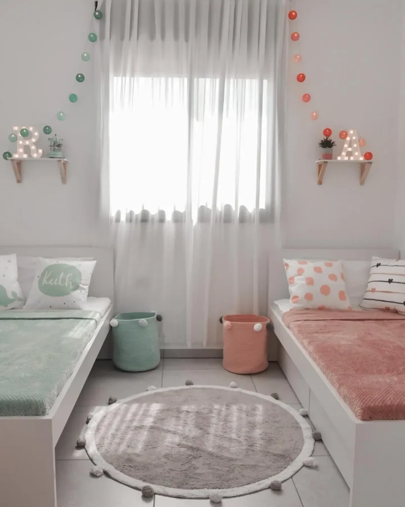 Boy and girl shared bedroom with pastel pink and mint green bedding, matching storage baskets, and string lights.
