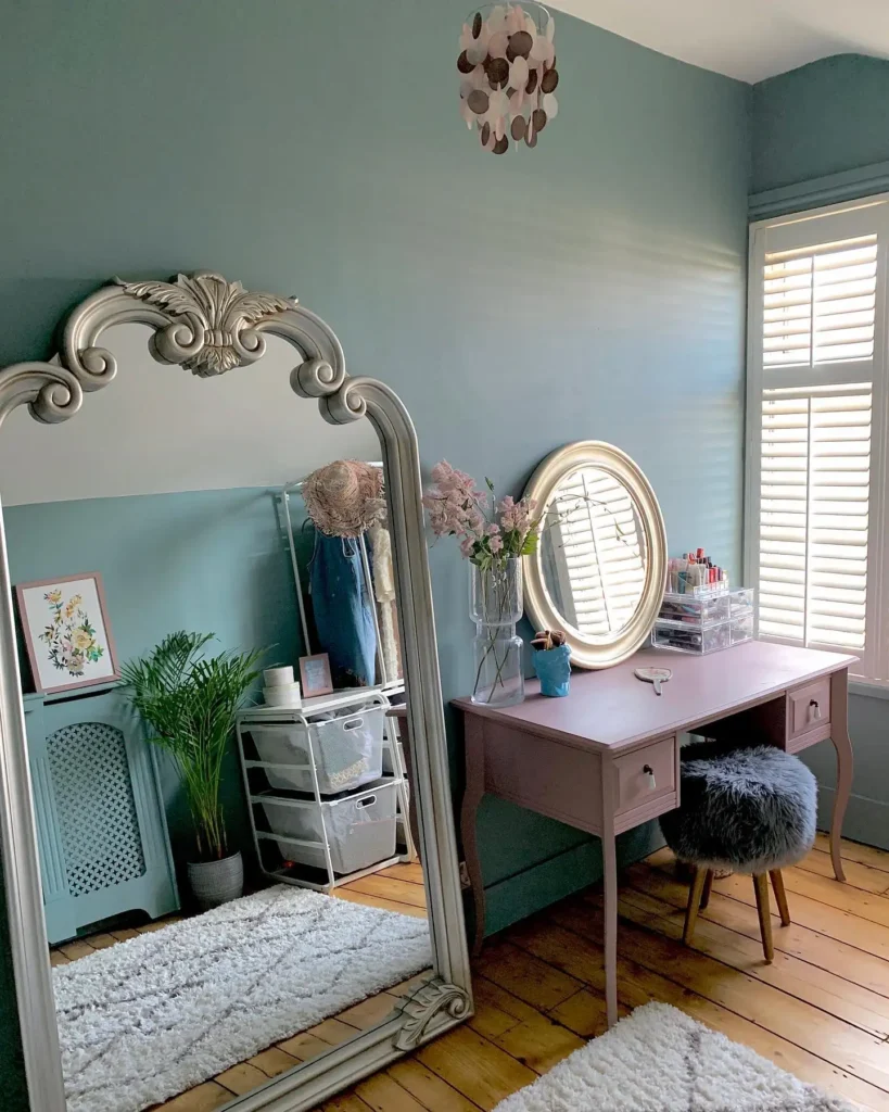 Bedroom with ornate silver framed full length mirror next to vanity desk.
