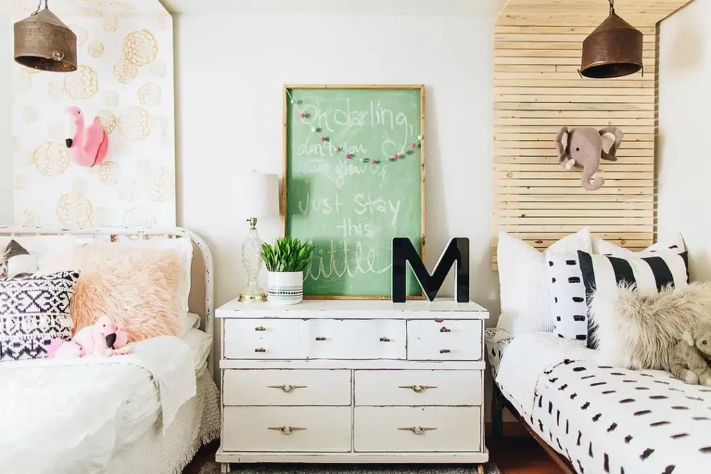 Boy and girl shared bedroom with playful flamingo and elephant décor, eclectic patterns, and vintage dresser.