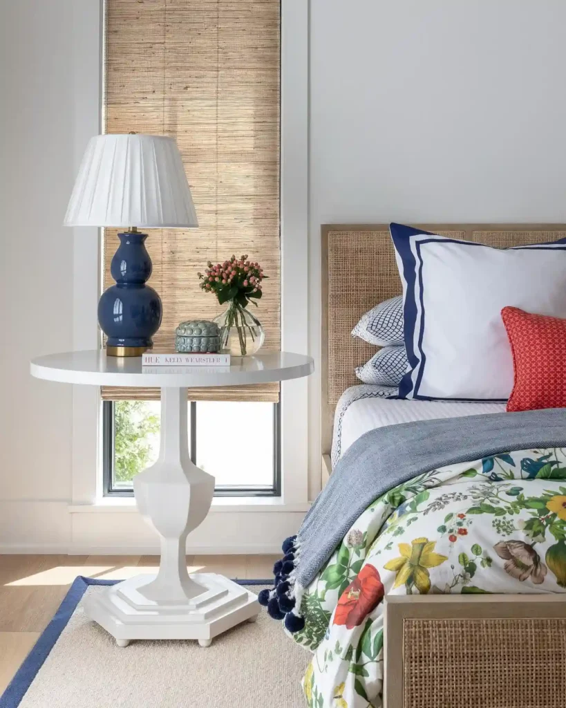 Guest bedroom bedding with floral quilt, blue trim pillows, and colorful accents.
