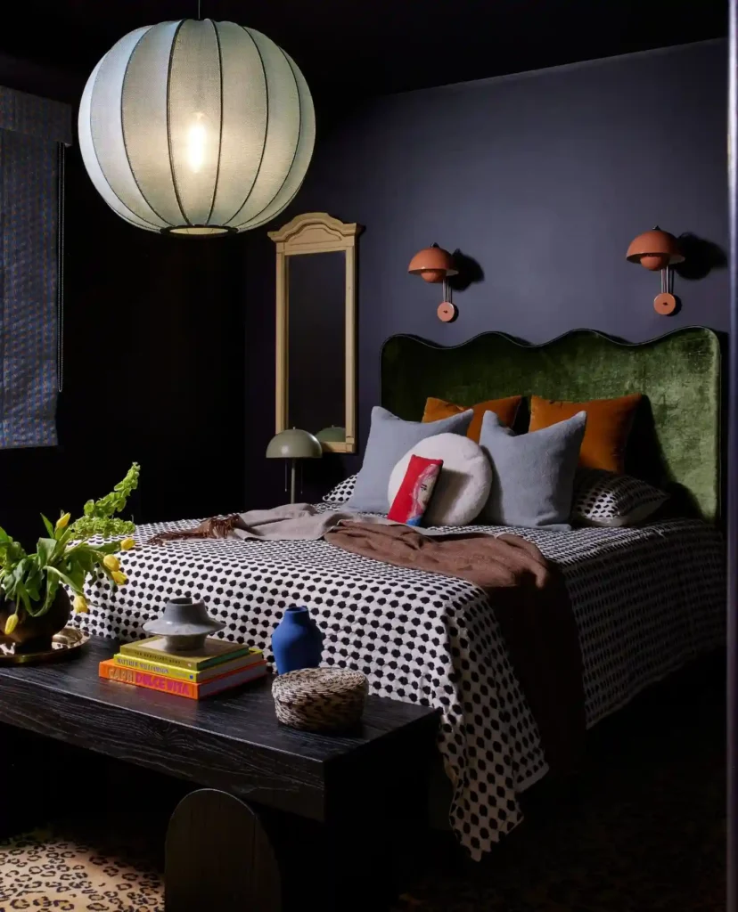 Guest bedroom bedding with bold patterned duvet, velvet headboard, and moody walls.
