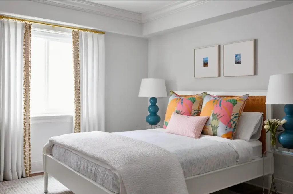 white bedding, turquoise lamps, and colorful pillows.
