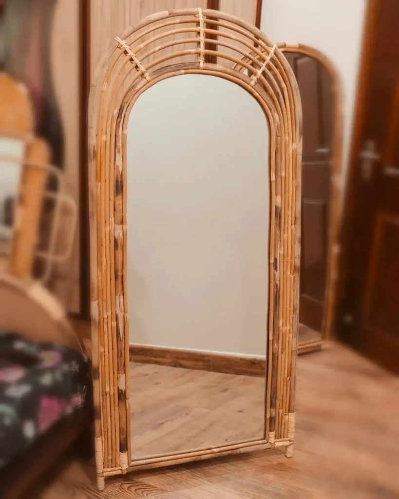 Full length mirror framed with rattan in bohemian styled bedroom.
