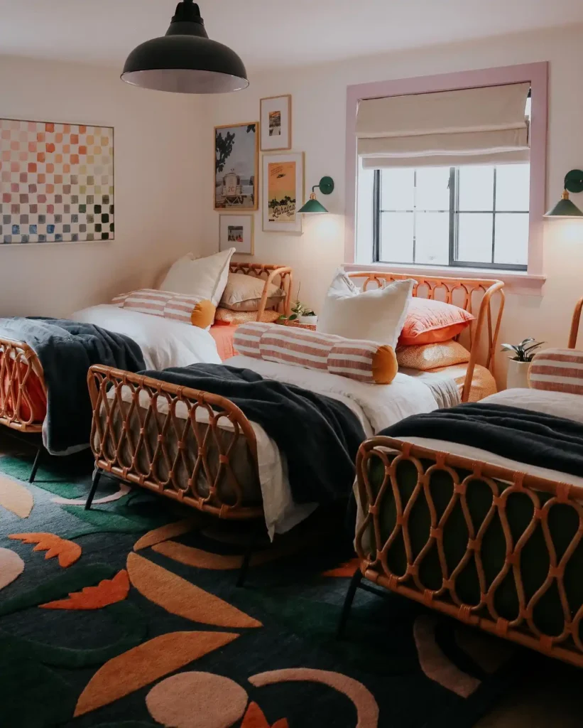Basement guest bedroom with three matching beds, striped linens, and playful rugs.
