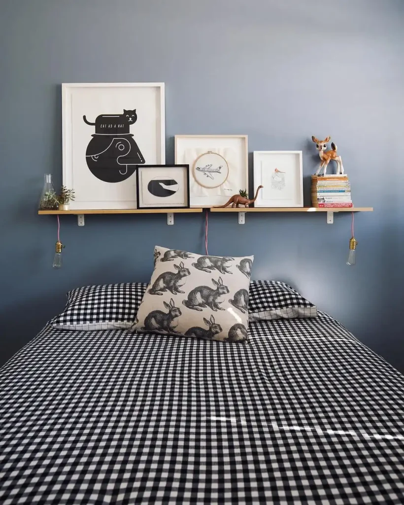 Guest bedroom idea on a budget with blue accent wall, floating shelf, and black gingham bedding.