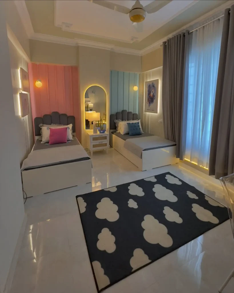 Boy and girl shared bedroom with pastel pink and blue feature walls, modern twin beds, and soft lighting.