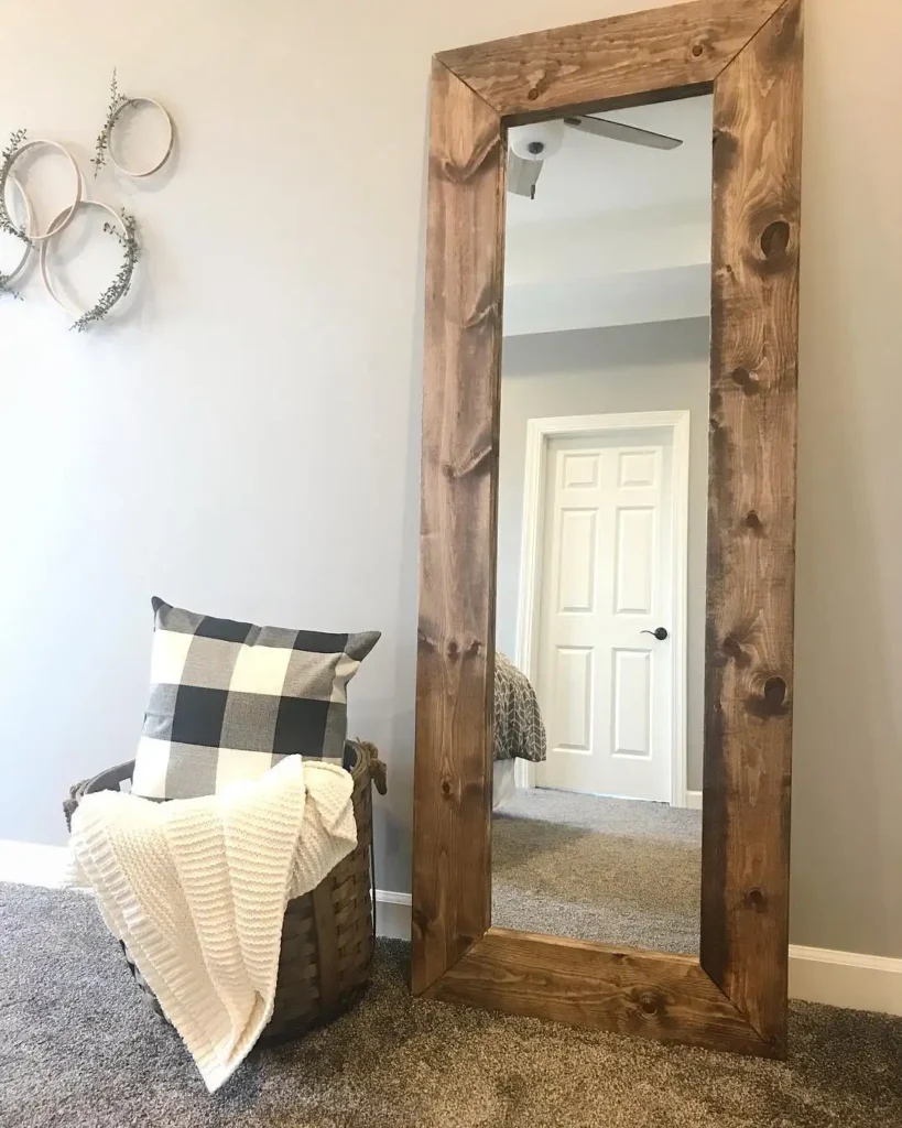 Rustic full length mirror in bedroom with thick wood frame and cozy basket