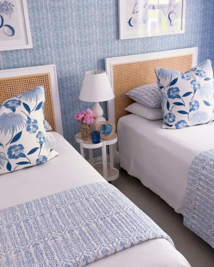 Twin beds with blue floral bedding, rattan headboards, and patterned pillows.