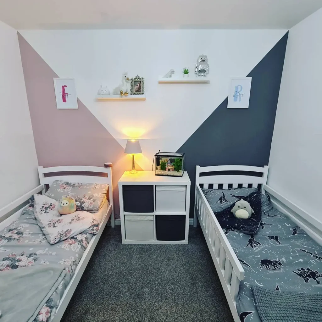 Boy and girl shared bedroom with geometric wall paint, twin beds, and simple storage.
