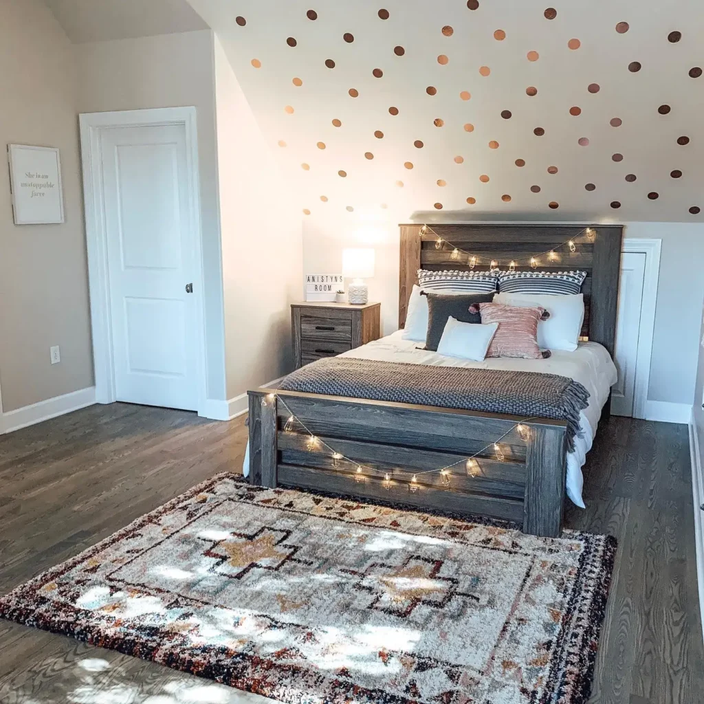 Preteen girls bedroom ideas featuring string lights on a wooden bed frame, patterned rug, and neutral bedding with pink accents.