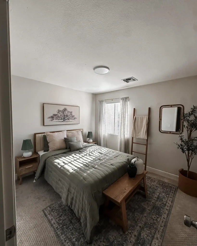 Guest bedroom idea on a budget with green bedding, wooden furniture, and natural textures.