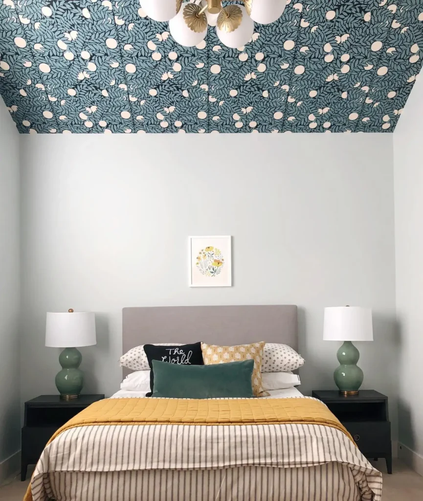 Preteen girls bedroom featuring bold patterned ceiling, striped bedding, mustard blanket, and modern lamps.
