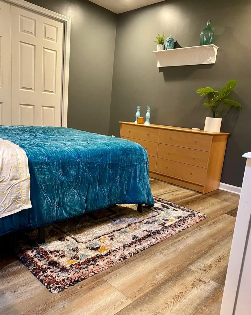 teal bedding, large dresser, and floating wall shelf.