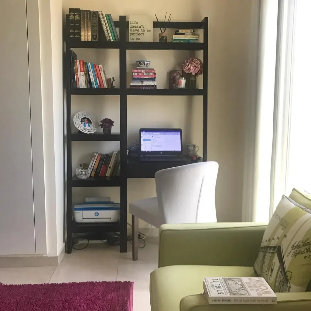 black bookshelf desk, white chair, green armchair, and decorative accents in a cozy layout.