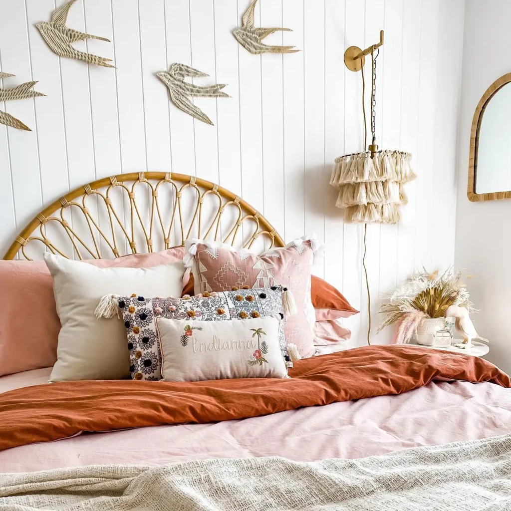 Preteen girls bedroom decorated with woven wall art, rattan headboard, tassel lamp, and blush pink bedding.
